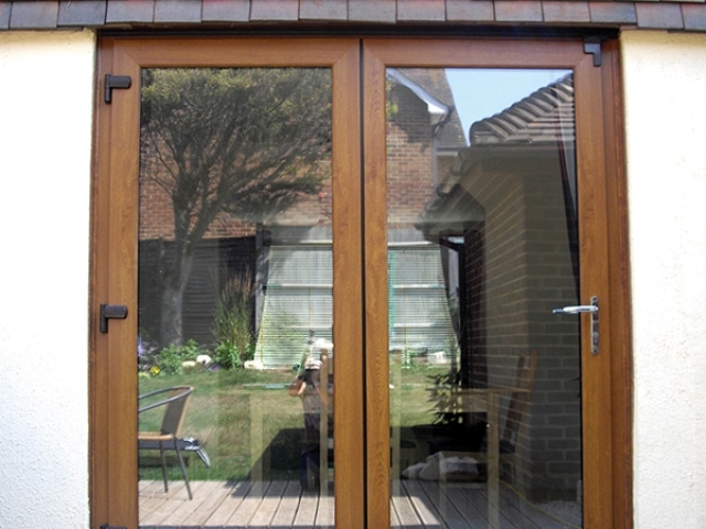 Wooden bifold patio door highlighted by a blue circle, showcasing its design and structure.