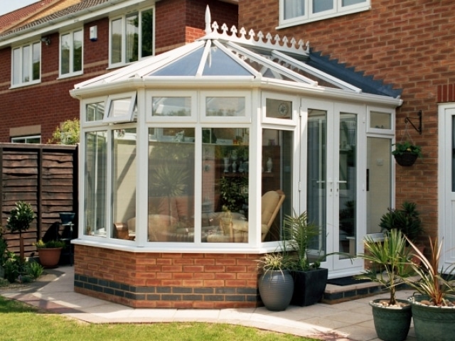 a victorian conservatory in a sunny suburban garden