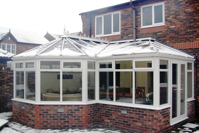 side view of a p-shaped conservatory covered with snow