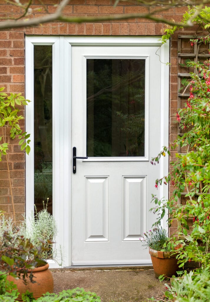 White uPVC front door with green plants