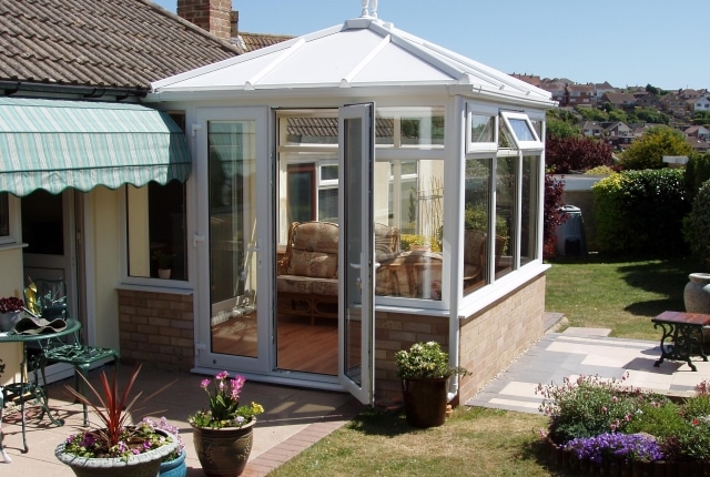a small edwardian conservatory in a sunny seaside garden