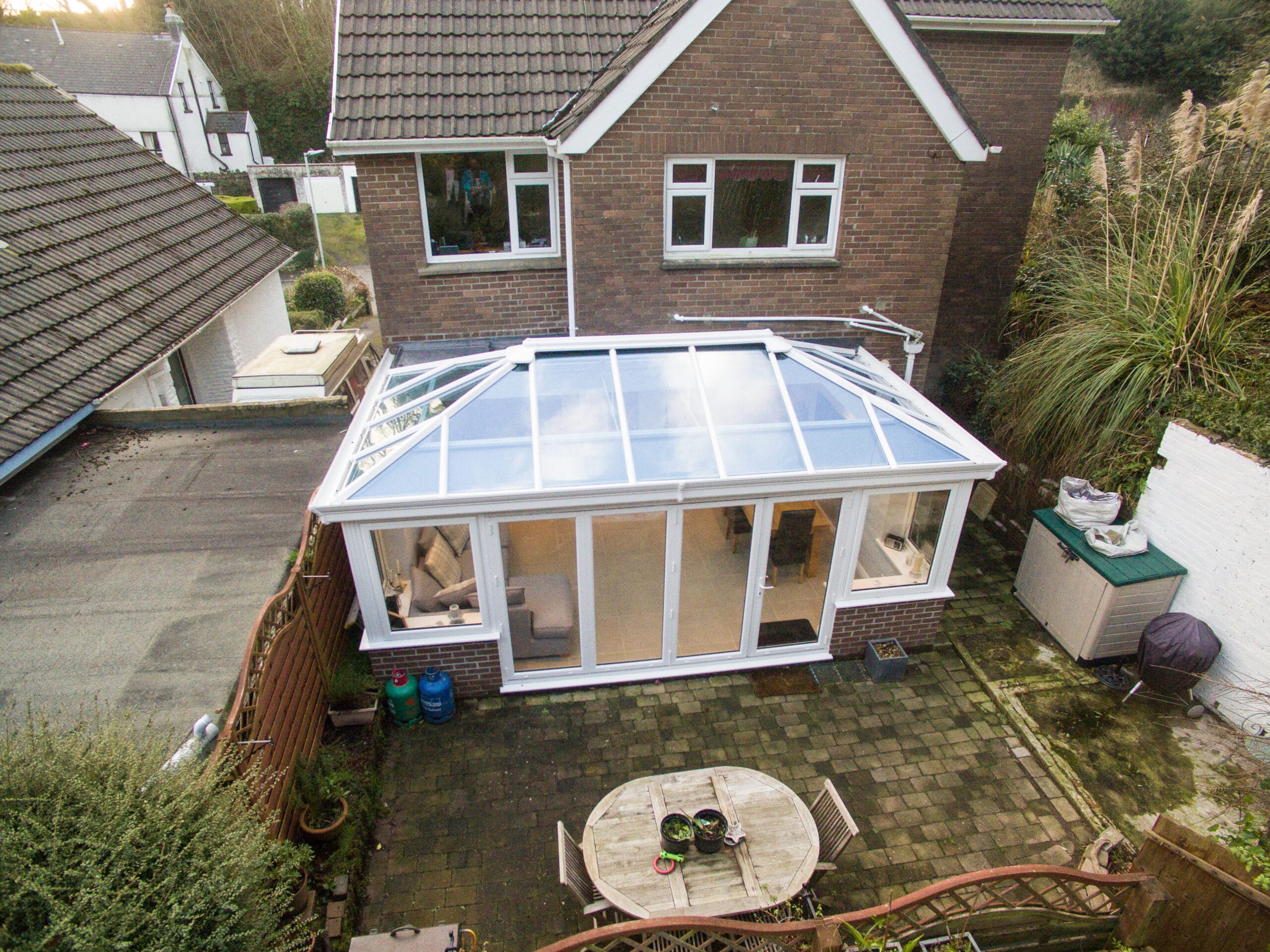 Aerial view of an Edwardian conservatory patio featuring a glass roof, showcasing its elegant design and spacious layout.
