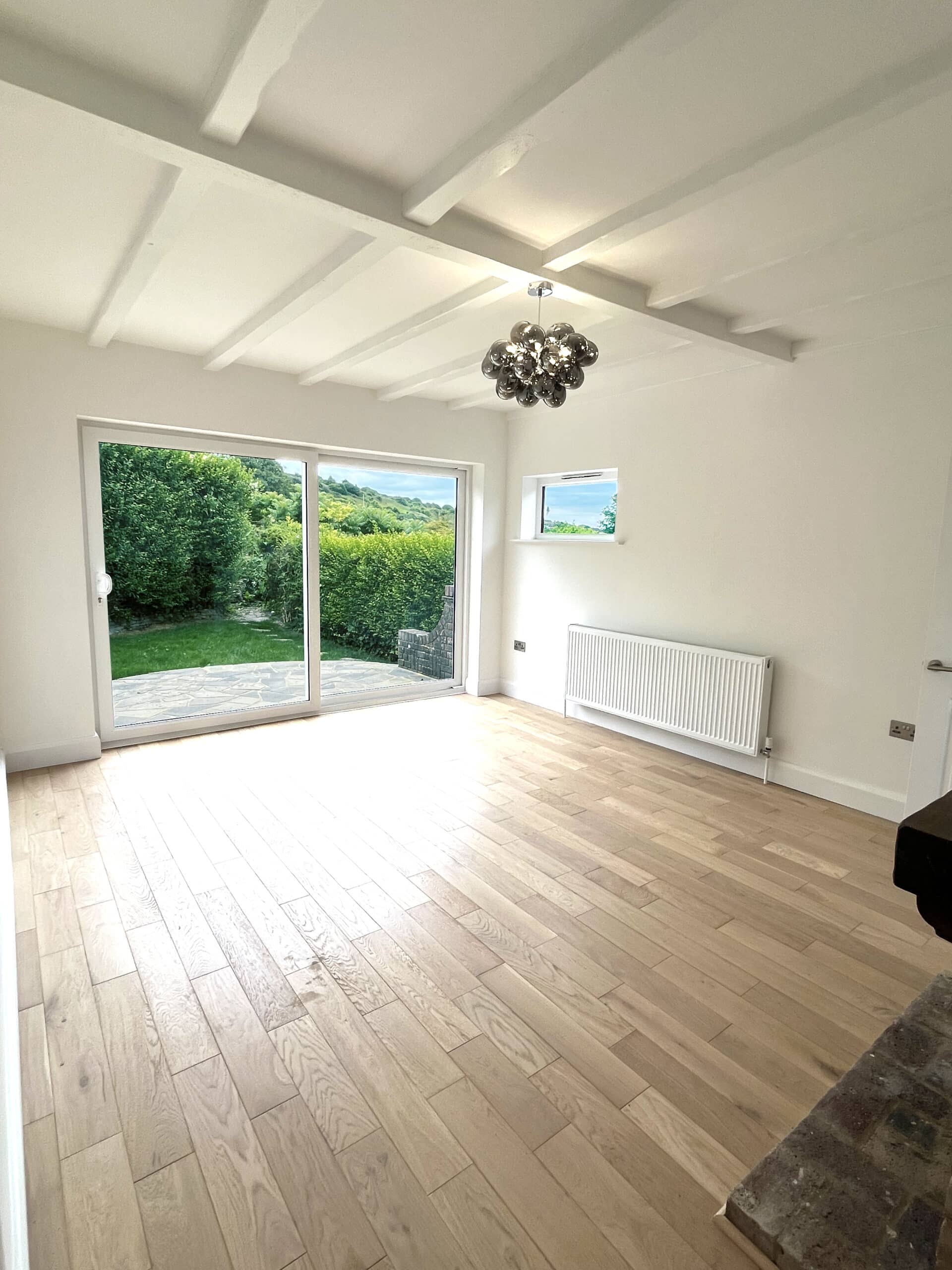 A room with hardwood floors and a sliding door, allowing natural light to fill the space.